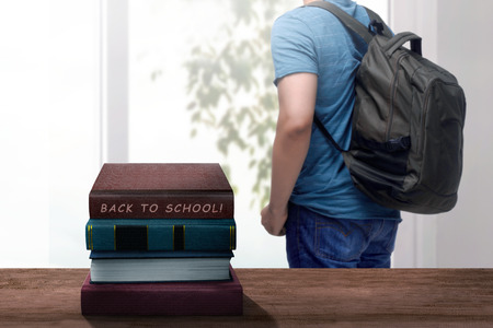 Student looking through the window with back to school message at bookの写真素材
