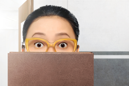 Beautiful asian student woman with eyeglasses and book on the classroomの写真素材