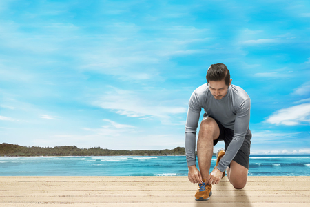 Handsome asian man ready to doing exercise with seascapes backgroundの写真素材