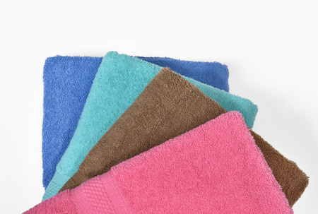 Pile of tidy folded towels isolated over white backgroundの写真素材