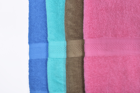 Pile of tidy folded towels isolated over white backgroundの写真素材