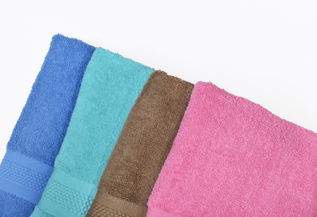 Pile of tidy folded towels isolated over white backgroundの写真素材