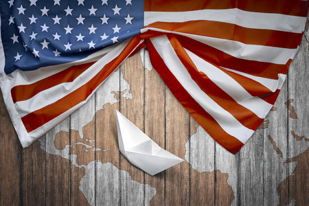 American flags and paper boat with wooden background. Columbus day conceptの写真素材