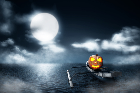 Halloween pumpkin in wooden boat on foggy lake at nightの写真素材