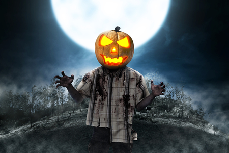 Zombie man with pumpkin head over full moon background. Halloween conceptの写真素材