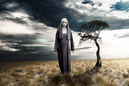 Scary devil nun with dark sky background. Halloween conceptの写真素材