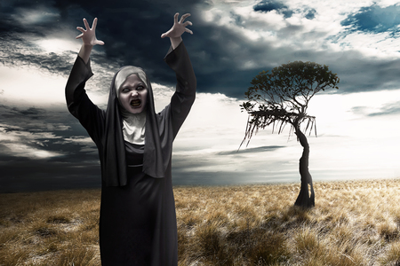 Scary devil nun with dark sky background. Halloween conceptの写真素材
