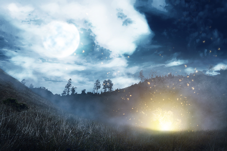 Misty hill with dark cloud and full moon on the night. Halloween backgroundの写真素材