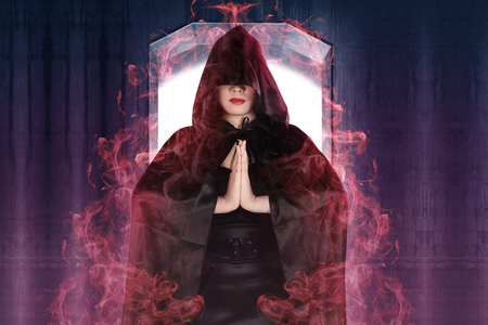 Attractive witch woman showing her magic power with wall backgroundの写真素材