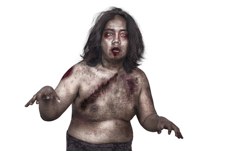 Portrait of zombie man with dirty body posing isolated over white backgroundの写真素材