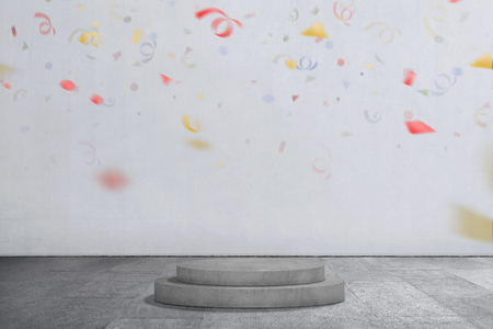 Podium circle with confetti in the air against gray wall backgroundの写真素材