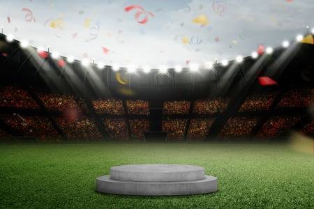 Podium with flying confetti on the stadium grassの写真素材