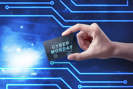 Hands holding card with Cyber Monday text against digital blue backgroundの写真素材