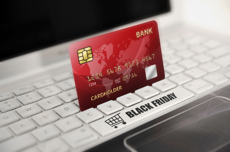 Red credit card with Black Friday text on laptop keyboardの写真素材