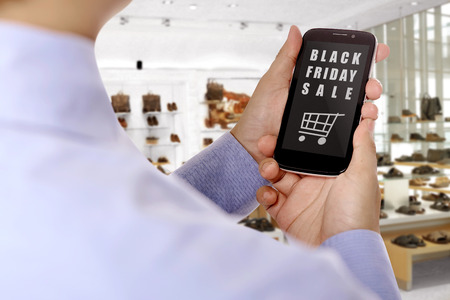 People holding mobile phone with black friday sale text on screen. Black friday conceptの写真素材