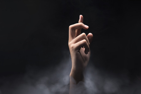 Hands finger with cross gesture over dark background. Christian Prayの写真素材