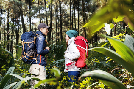 Portrait of asian hikers couple standing and looking each other on the forestの写真素材