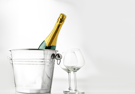 Wine bottle on ice bucket with two wine glasses isolated over white backgroundの写真素材