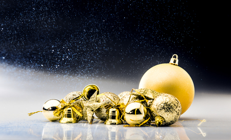 Golden christmas balls and bells with glitter backgroundの写真素材