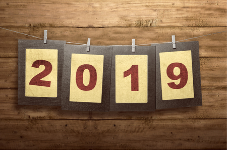Hanged paper on the rope with 2019 number display on wooden background. Happy New Year 2019の写真素材
