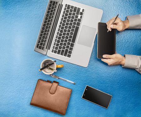 Businessman working using digital tablet, laptop, mobile phone on office desk. View from aboveの写真素材