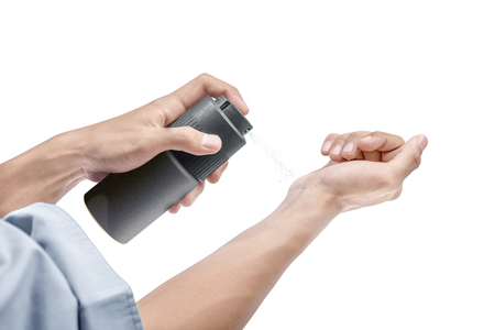 Businessman spraying perfume on his hands isolated over white backgroundの写真素材