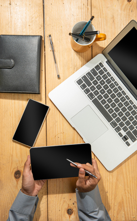 Businessman hands using tablet with stylus pen for work on the desk. View from aboveの写真素材