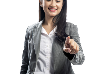 Beautiful asian business woman pointing something posing isolated over white backgroundの写真素材