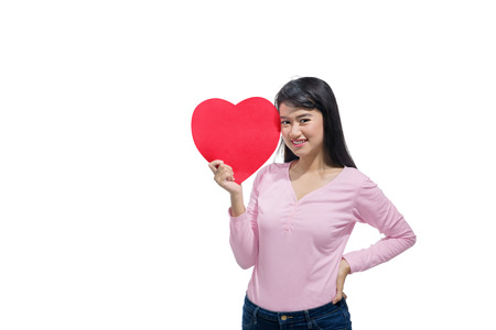 Pretty asian woman with red heart shape on her hands posing isolated over white background. Valentines dayの写真素材