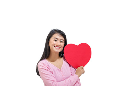Beautiful asian woman with red heart standing isolated over white background. Valentines dayの写真素材