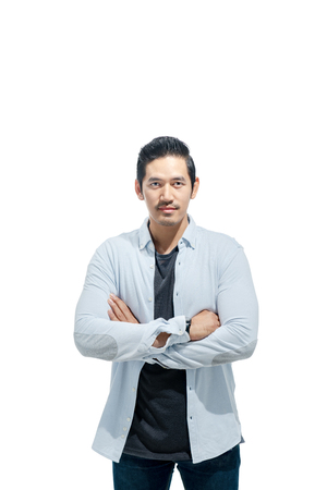 Handsome asian man in casual cloth crossed arms standing isolated over white backgroundの写真素材
