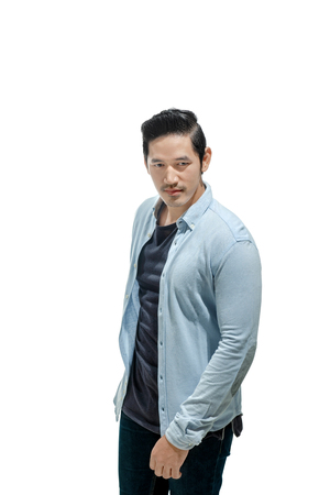 Handsome asian man in blue shirt standing isolated over white backgroundの写真素材