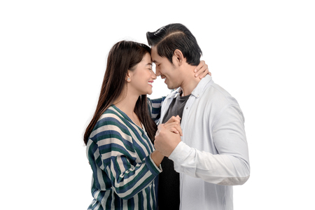 Romantic asian couple hugging and holding hands posing isolated over white background. Love concept and Valentines dayの写真素材