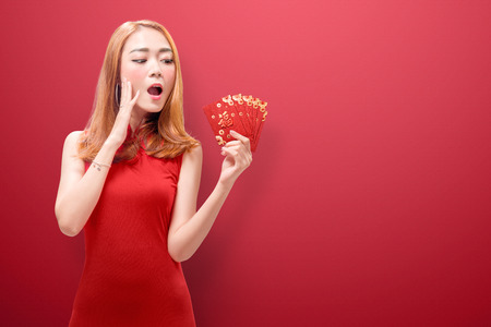 Happy chinese woman in cheongsam dress holding angpao. Happy Chinese New Yearの写真素材