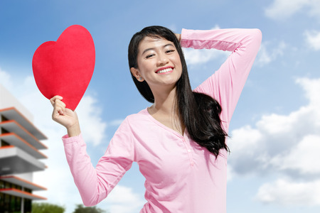 Cute asian woman with red heart paper on her hands. Valentines dayの写真素材