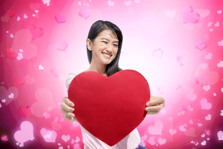 Pretty asian woman standing with red heart paper. Valentines dayの写真素材