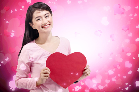 Beautiful asian woman holding red heart shape on her hands. Valentines dayの写真素材