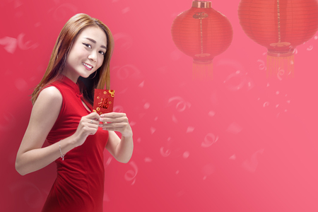 Attractive chinese woman with cheongsam dress holding angpao. Happy Chinese New Yearの写真素材
