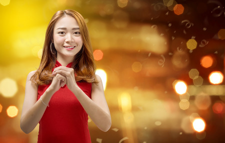Cheerful chinese woman in traditional dress with congratulation gesture. Happy Chinese New Yearの写真素材