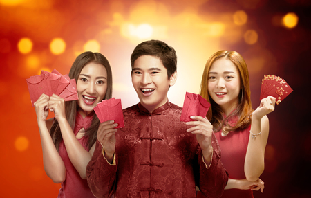 Portrait of chinese people in traditional dress holding red envelopes. Happy Chinese New Yearの写真素材