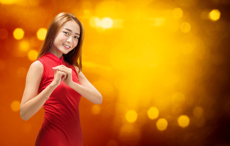 Young chinese woman in cheongsam dress with gesture of congratulation. Happy Chinese New Yearの写真素材
