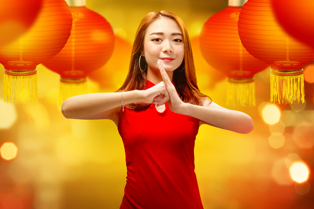 Happy chinese woman with gesture of congratulation. Happy Chinese New Yearの写真素材