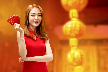 Happy chinese woman in cheongsam dress and red envelopes. Happy Chinese New Yearの写真素材
