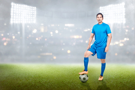 Professional asian soccer player man standing with ball on his leg in the stadium fieldの写真素材