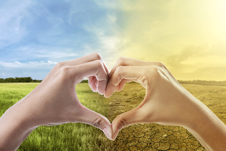 Human hands with heart shape against climate change on the background. Global awareness conceptの写真素材