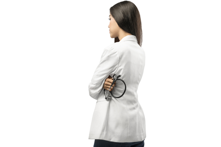 Rear view of asian doctor woman in white coat holding stethoscope standing isolated over white backgroundの写真素材