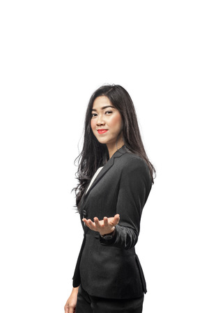 Pretty asian businesswoman with open palm showing something standing isolated over white backgroundの写真素材
