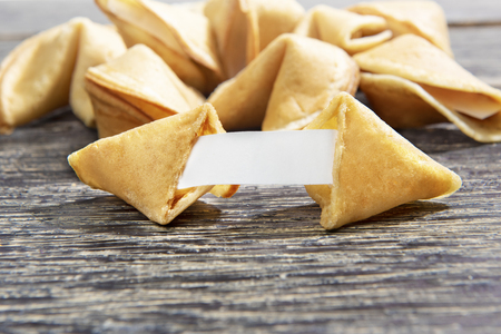 Opening fortune cookies with blank white paper on the tableの写真素材