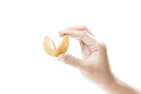 Human hand holding fortune cookies isolated over white backgroundの写真素材
