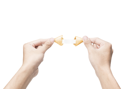 Human hand opening a fortune cookies with blank paper inside it isolated over white backgroundの写真素材